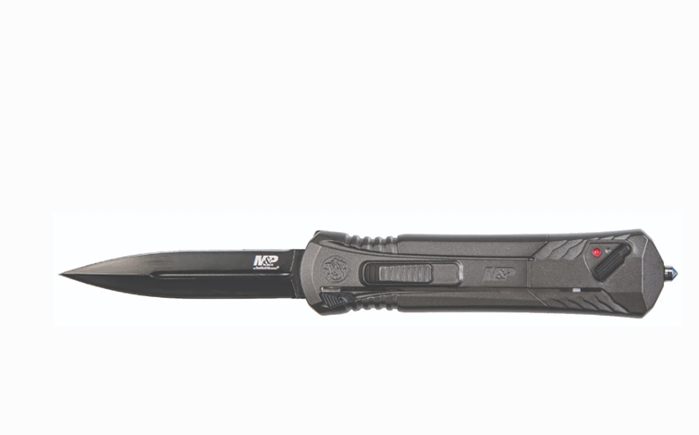 A black tactical folding knife with a partially serrated blade, featuring a textured handle and a red safety indicator.