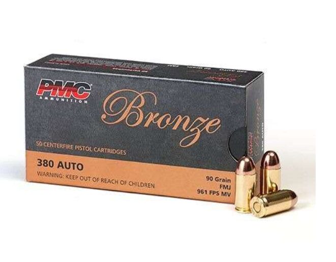 A box of pmc bronze 380 auto 90 grain fmj pistol cartridges with two bullets in front of it.